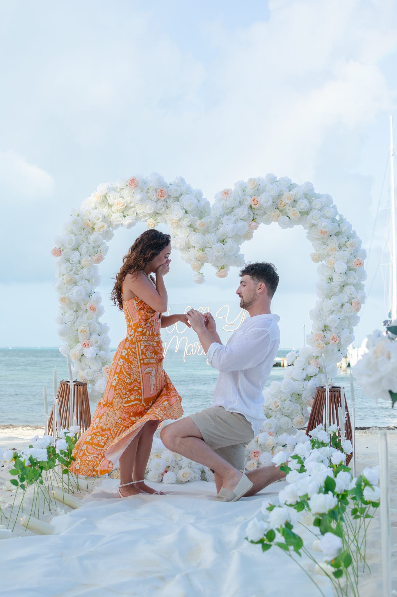 Complete Caribbean beach engagement setup in Tulum including a decorated teepee, floor cushions, and a gourmet picnic spread for two.