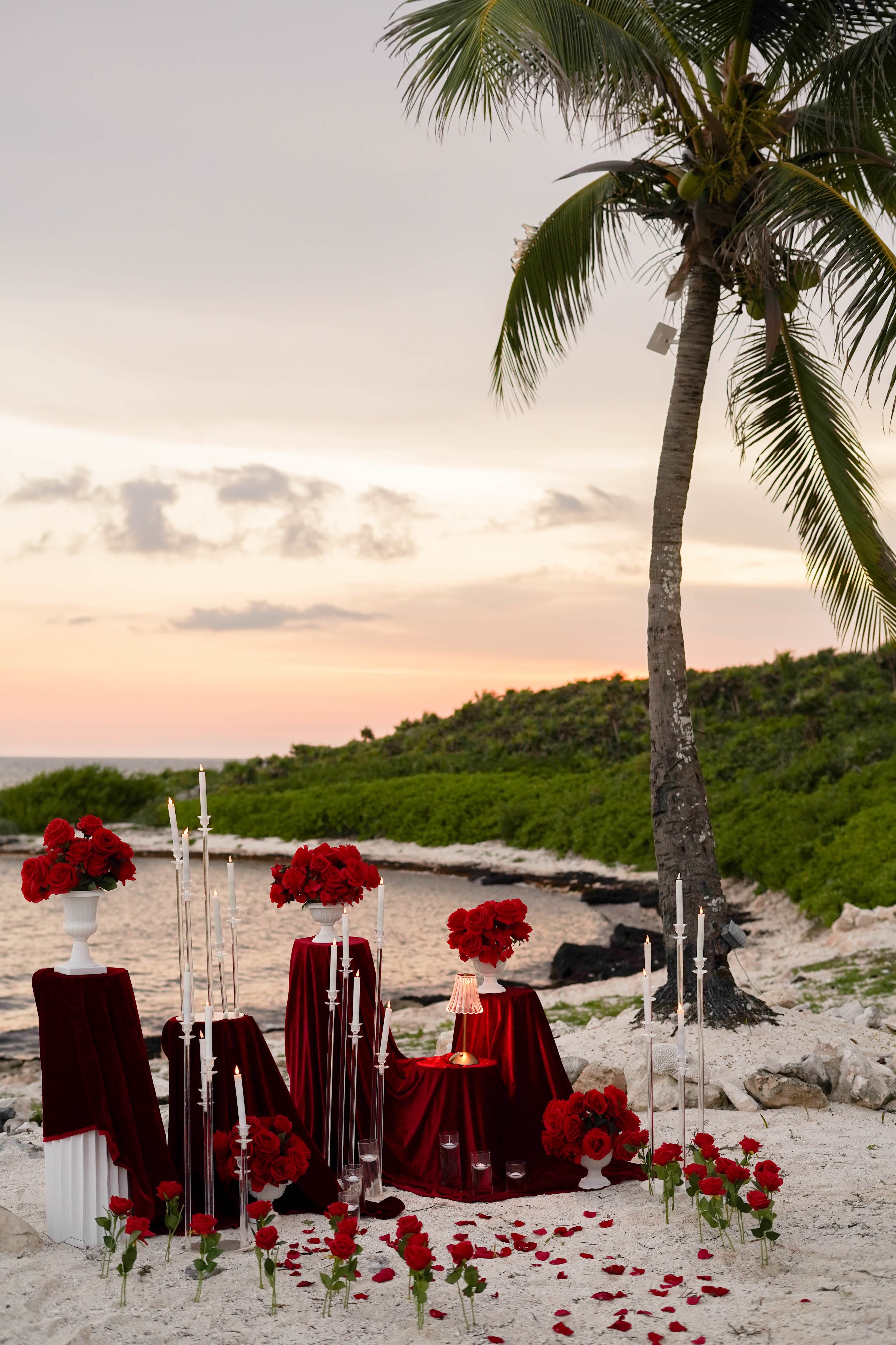 Intimate Caribbean beach engagement in Akumal featuring a low-profile picnic table, boho-chic floor cushions, and a quiet, romantic atmosphere.