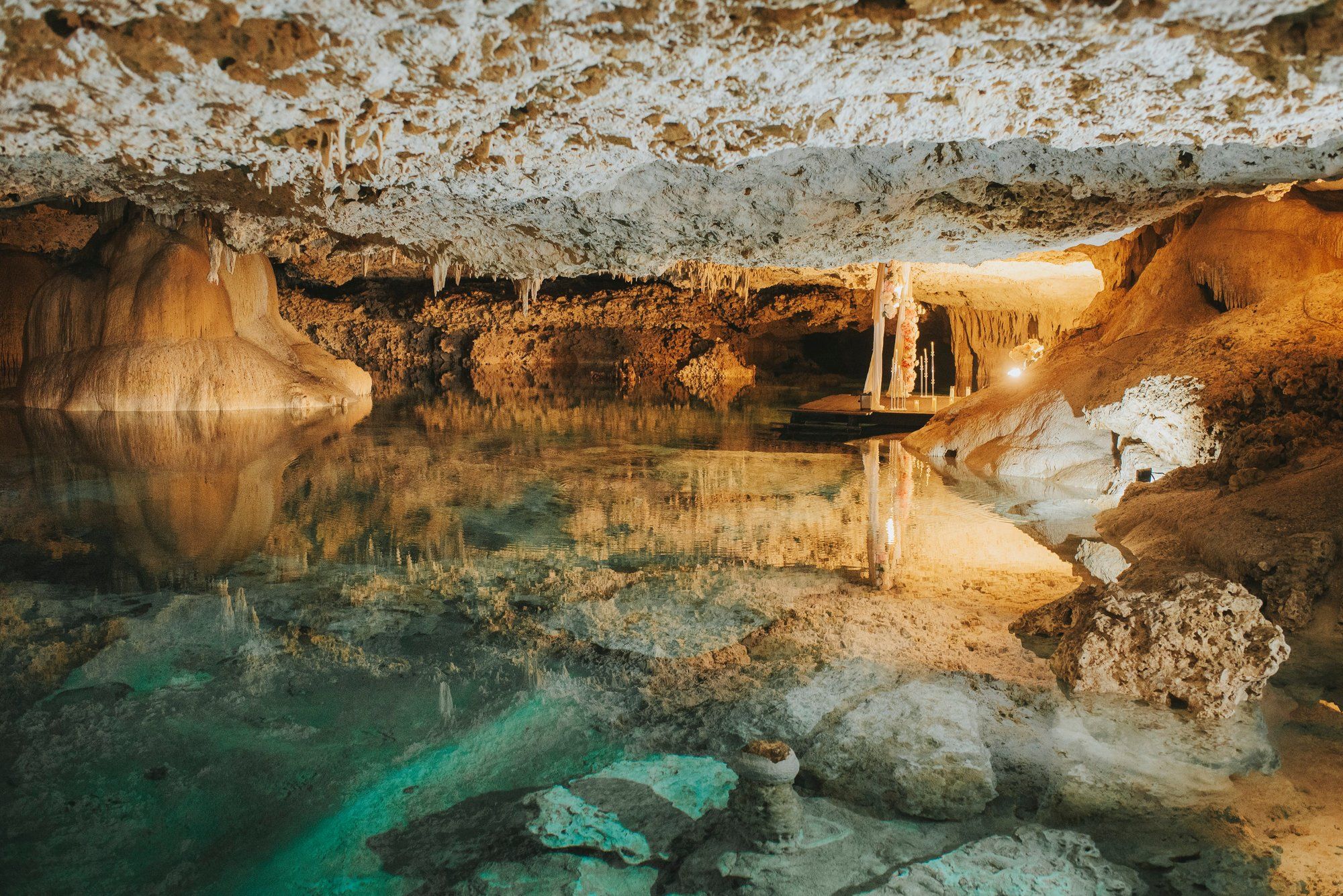 Breathtaking cenote ceremony near Cancun featuring a grand floral setup and a majestic Mayan backdrop for a once-in-a-lifetime proposal.