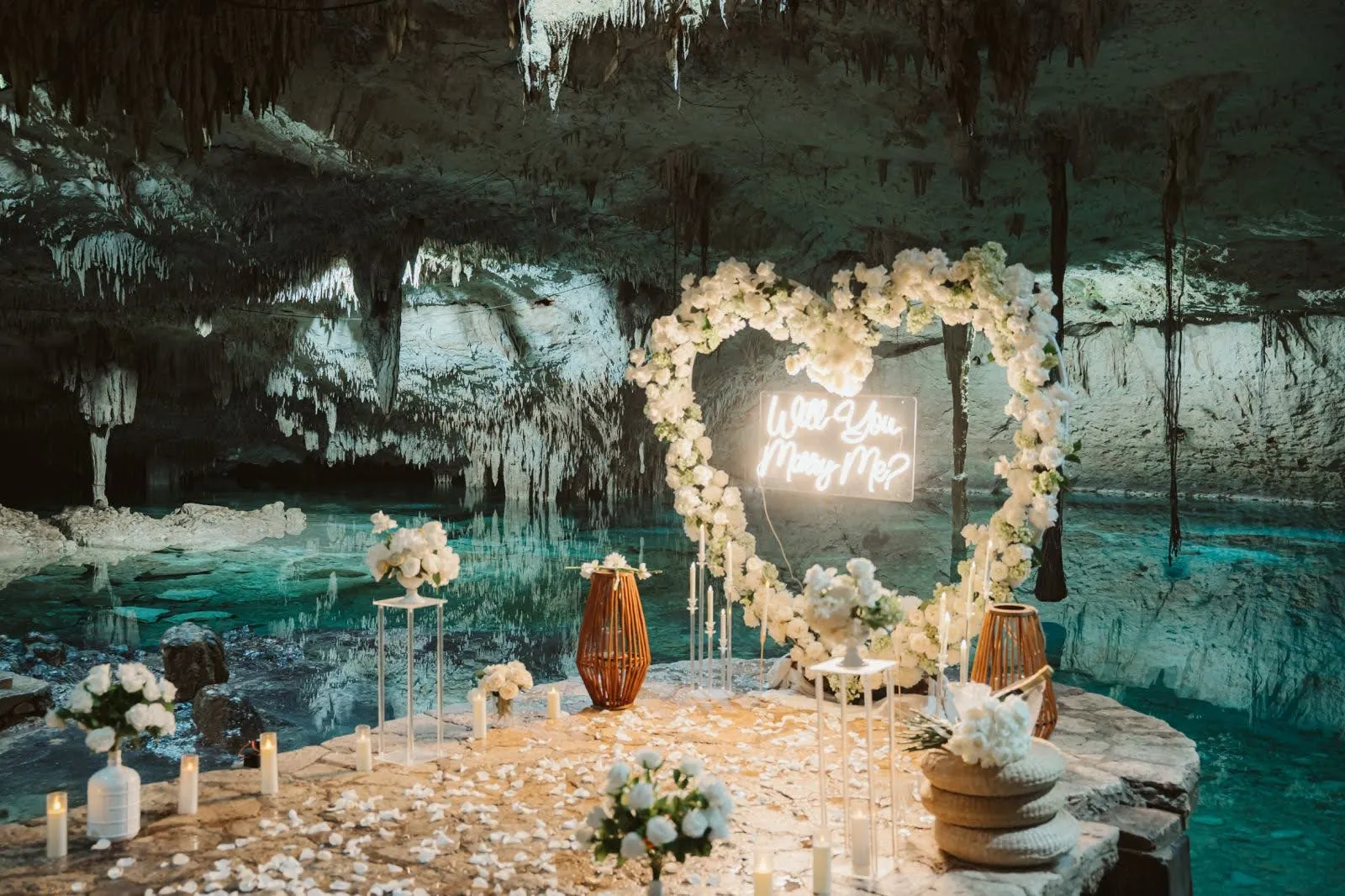 Montaje de propuesta privada en un cenote con flores y velas en Riviera Maya