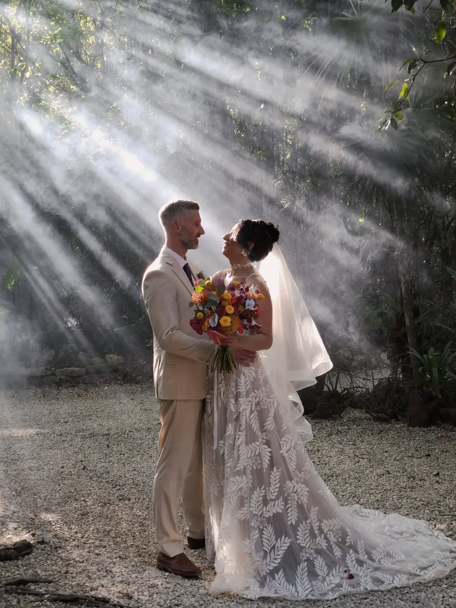 Couple beneath sunbeams during a cenote wedding