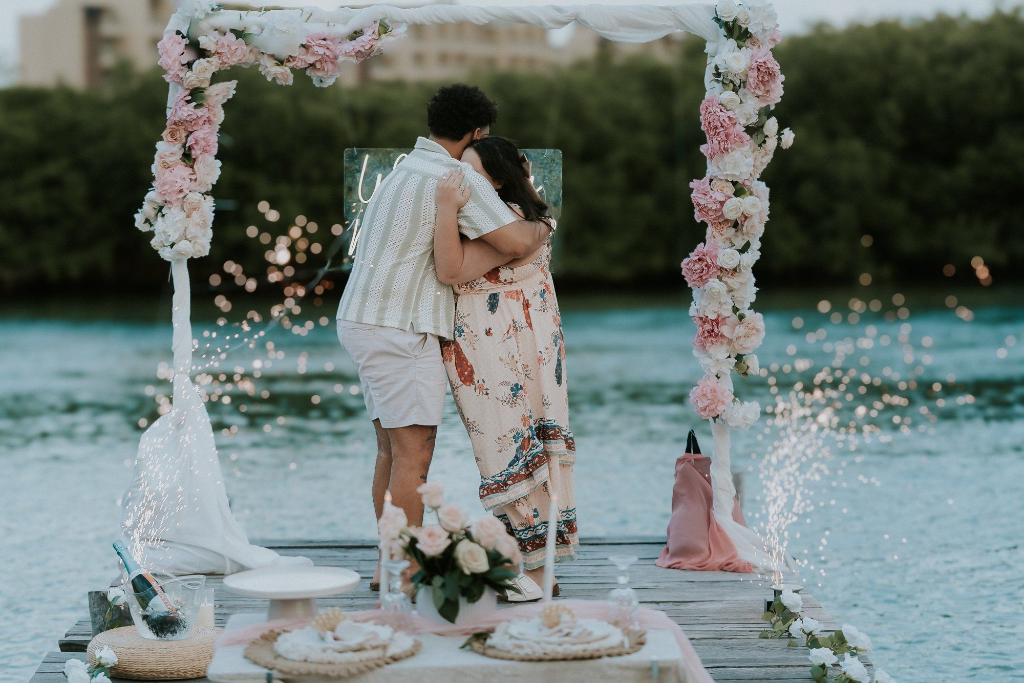 Romantic terrace engagement in Akumal with a white floral arch and a direct view of the azure reef and crashing waves.