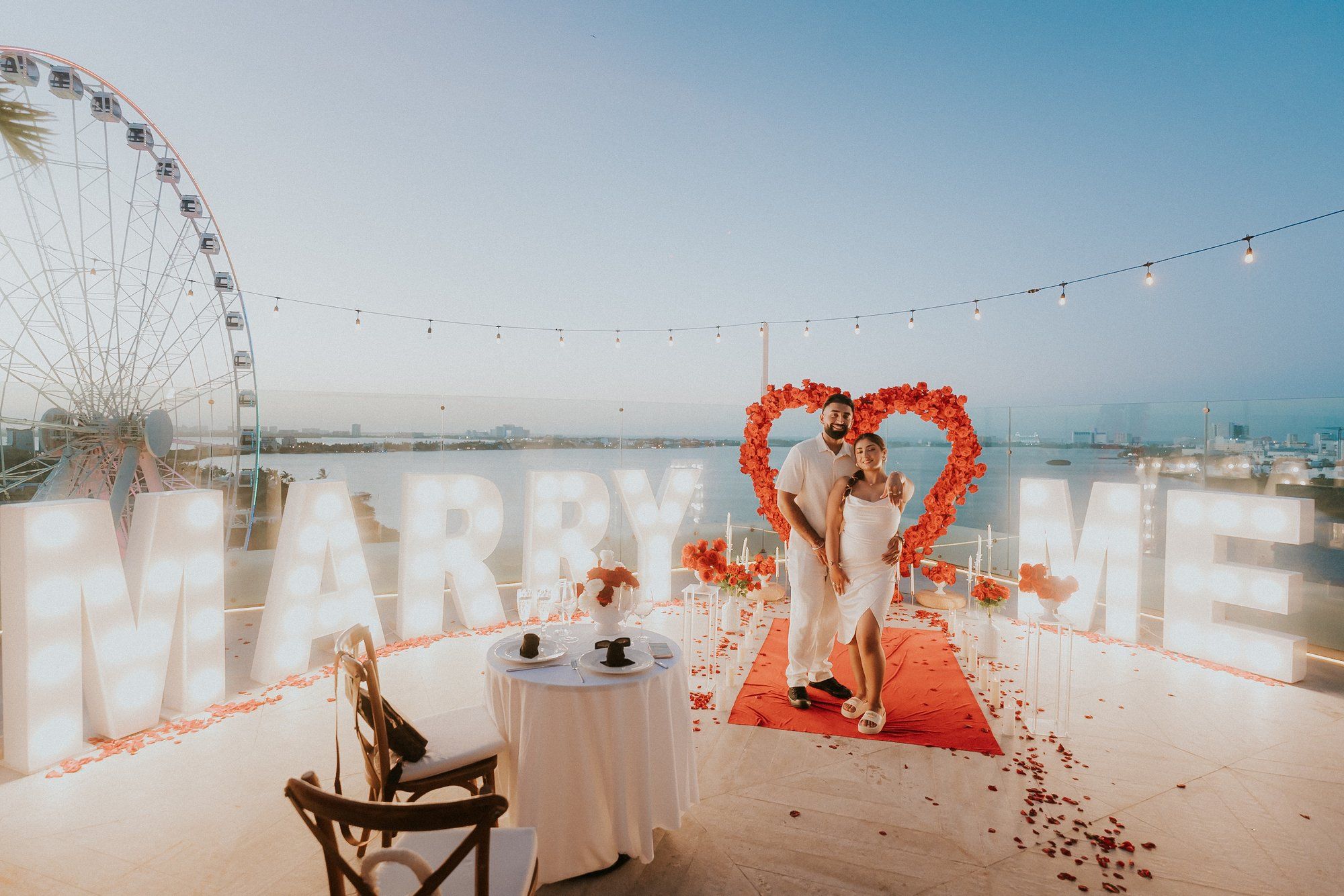 Romantic deck proposal setup in Akumal with a minimalist floral heart and a quiet, private atmosphere for the perfect 'Yes'.