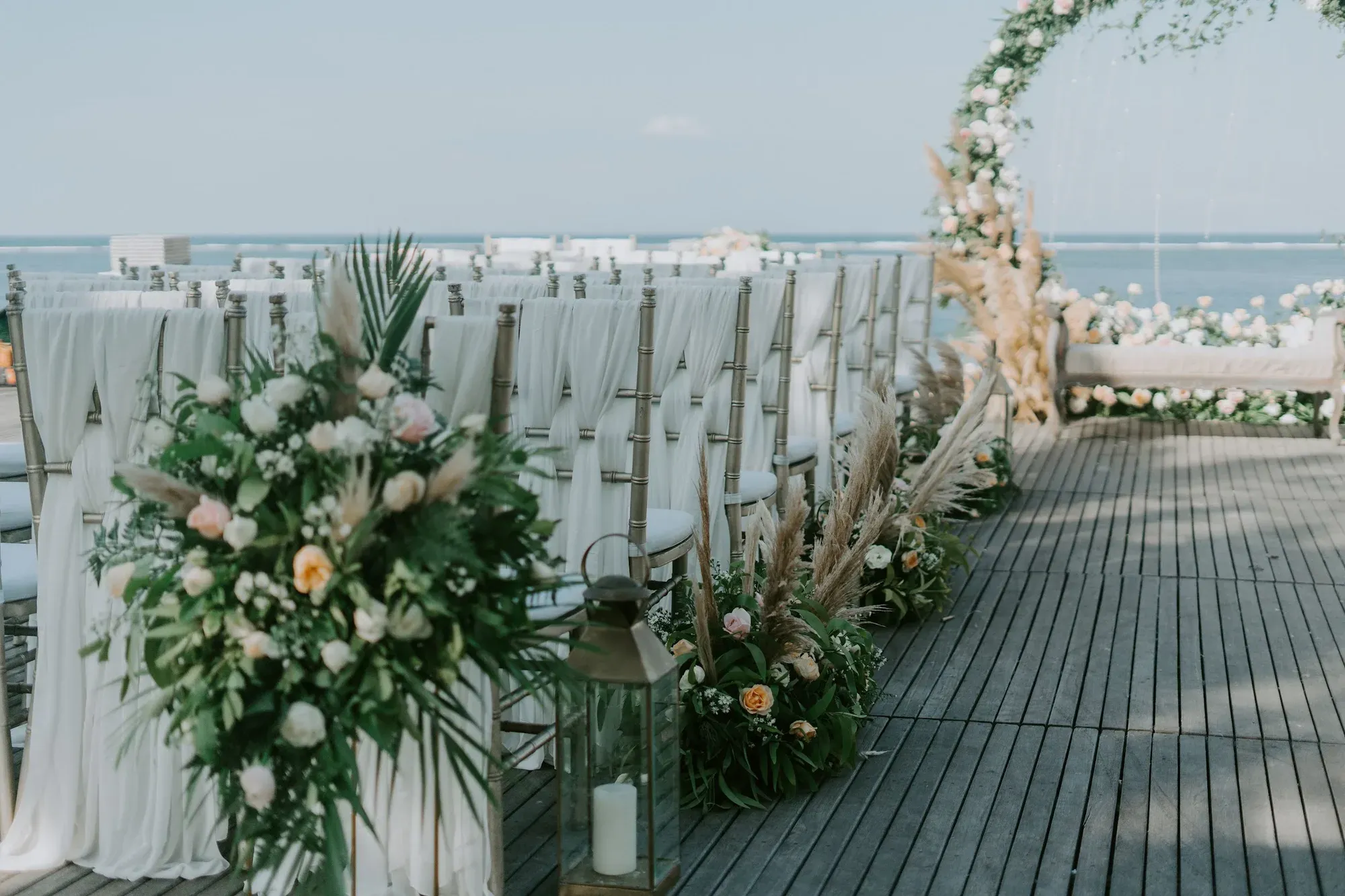 Seaside ceremony aisle lined with white florals