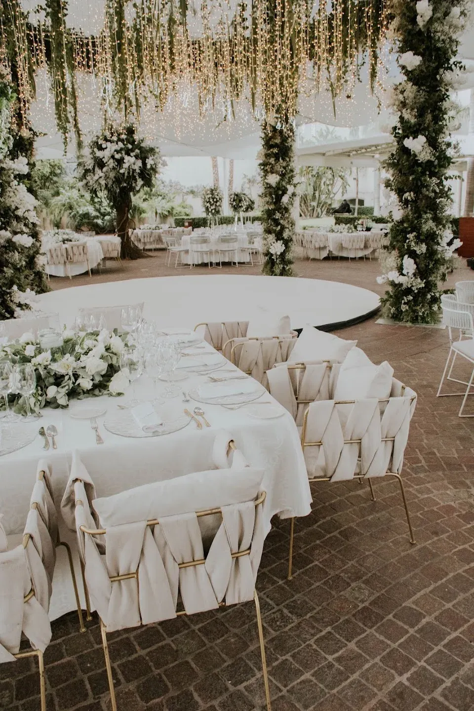 Ceremony stage with white florals and tropical greenery