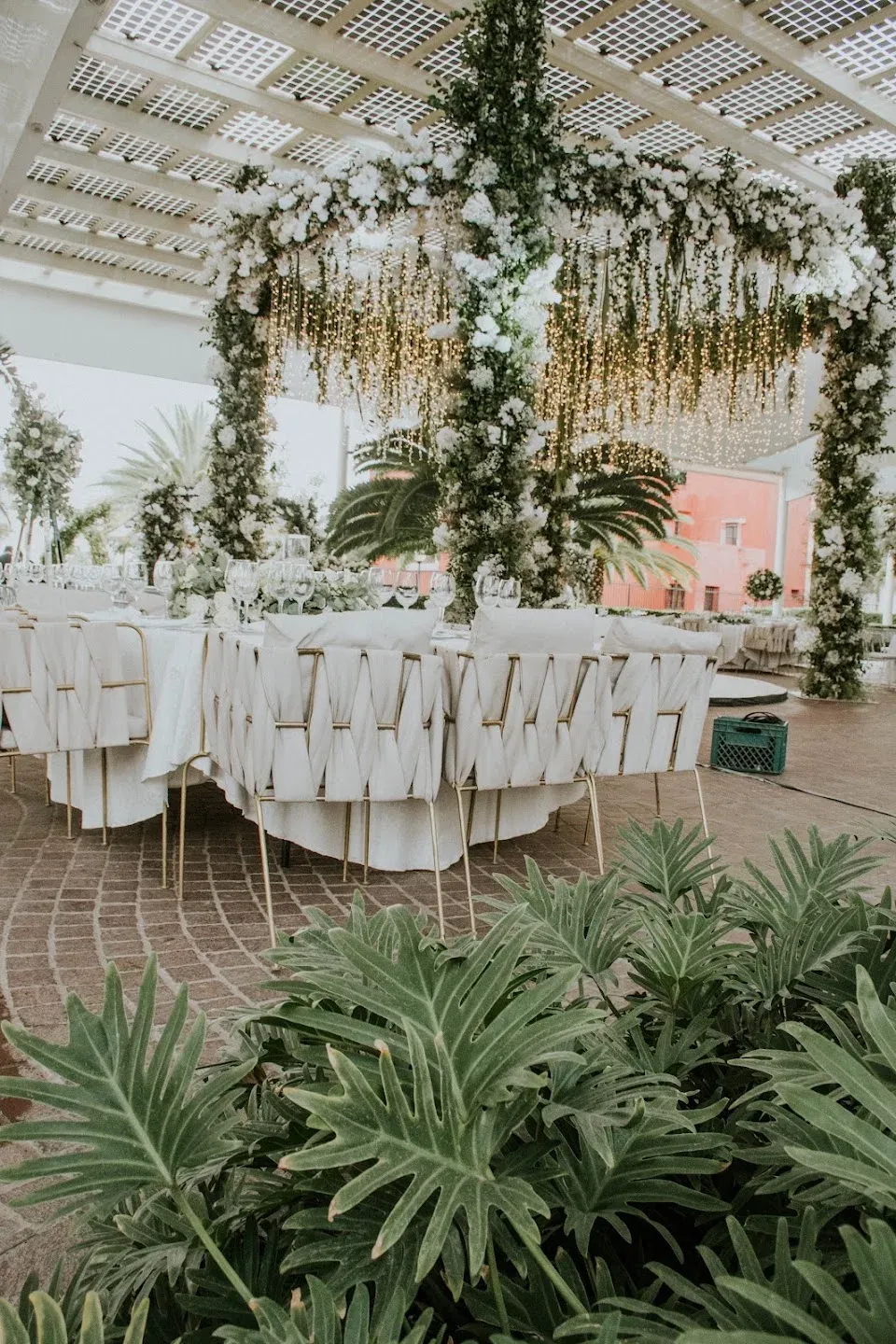 White reception tables with tropical floral decor